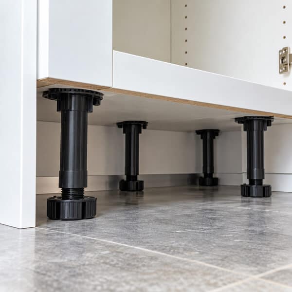 Exposed Black Cabinet Legs Beneath White Base